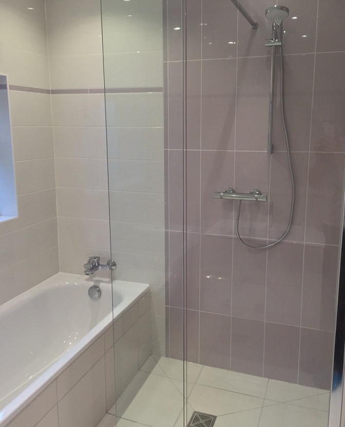 Bath with a glass shower screen