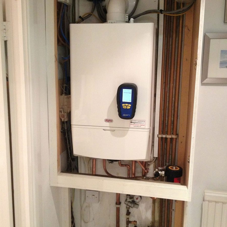A wall-hung boiler being commissioned with a flue gas analyser
